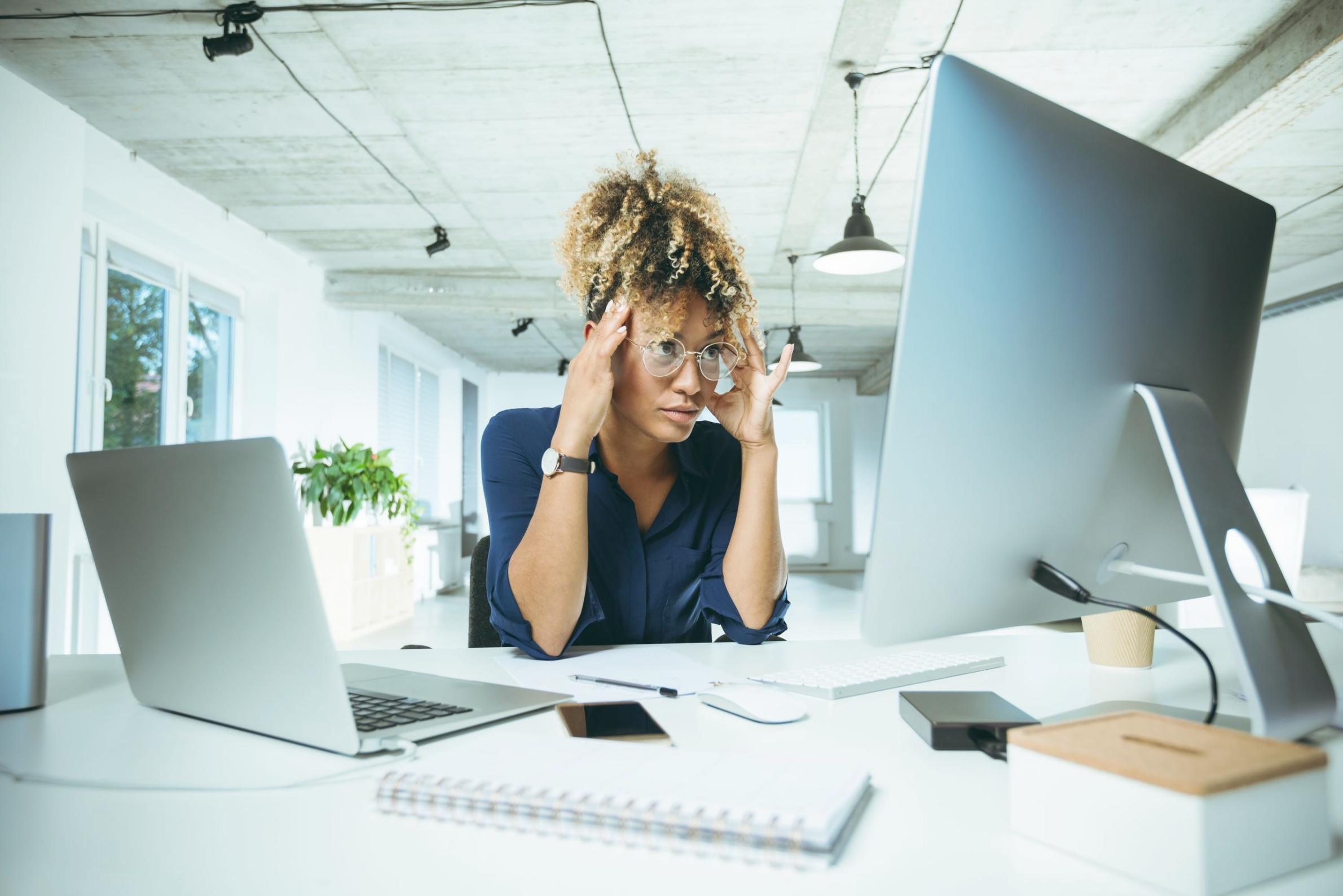 Manos escribiendo en libreta de presupuesto junto a taza de café